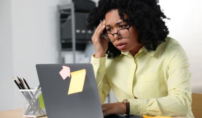 empreendedora negra olhando preocupada para um notebook - Assaí Atacadista - Black Friday para negócios