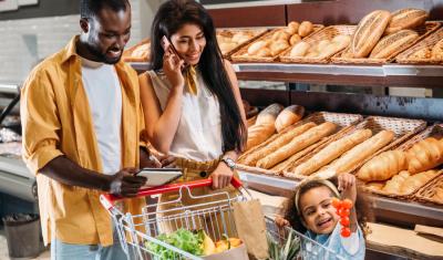 familia com homem mulher e criança negra felizes em um mercado com carrinho - Assaí Atacadista - dia do cliente