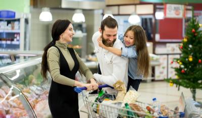 familia com mulher, homem e criança branca felizes com um carrinho em um mercado - Assaí Atacadista - compras de Natal