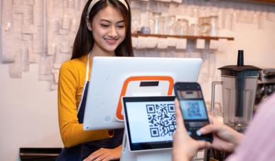 funcionária no caixa com um cliente lendo um qrcode - formas de pagamento - Assaí Atacadista