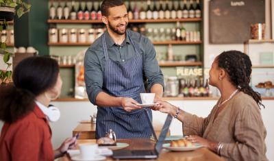 homem atendendo clientes em um café - semana do cliente assaí atacadista