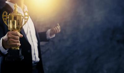 homem de social segurando troféu - Prêmio Consumidor Moderno 2024 - Assaí Atacadista