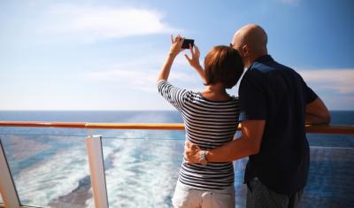 homem e mulher brancos tirando foto em um navio olhando para o mar - viagem de navio - Assaí Atacadista