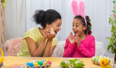 mãe e filha com orelha de coelha felizes brincando com ovos de páscoa coloridos - presentes de páscoa - assaí atacadista