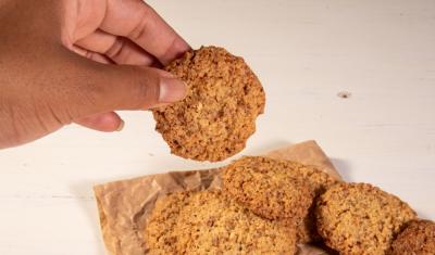 mão de uma pessoa negra segurando biscoitos - dia do biscoito - Assaí Atacadista