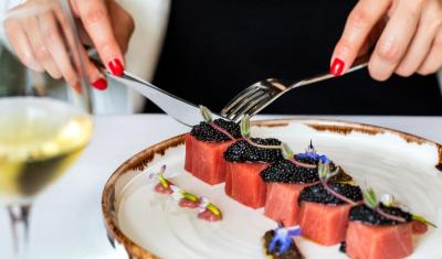 mãos brancas femininas fazendo uma refeição sofisticada com salmão e caviar em um prato - menu degustação - Assaí Atacadista