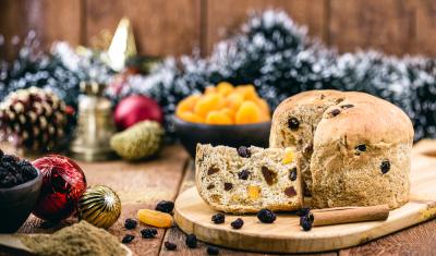 mesa com decorações de natal e um panetone cortado uma fatia-produtos sem glúten-Assaí Atacadista