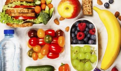 mesa com garrafa de água, frutas, barra de cereal e sanduíches naturais - lanches práticos - Assaí Atacadista