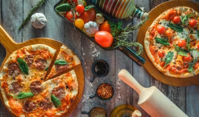 mesa com pizza e temperos - abrir uma pizzaria - Assaí Atacadista