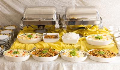 mesa de buffet com travessar cheia de comida - buffet de alimentos - Assaí Atacadista
