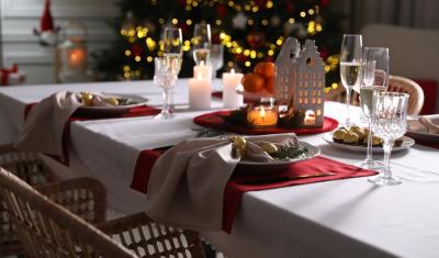 mesa posta simples com uma arvore de natal brilhando no fundo - Assaí Atacadista - mesa posta de natal