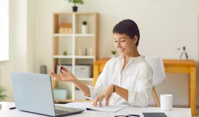 mulher branca contente estudando sobre desenvolvimento pessoal no notebook - Assaí Atacadista