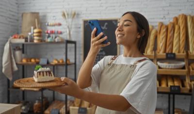 mulher jovem tirando foto de uma sobremesa em um prato-divulgação criativa-Assaí Atacadista