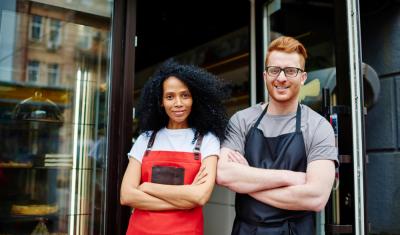 mulher negra empreendedora ao lado de um homem branco empreendedor ambos com os braços cruzados - Assaí Atacadista - parcerias locais