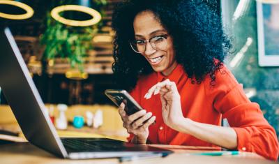 mulher negra usando celular - páginas do site Assaí Atacadista