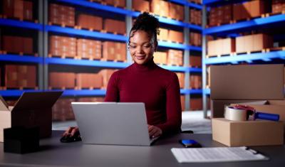 mulher negra usando notebook no estoque de uma loja-Assaí Atacadista-Lojas online