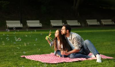 pai e filha brincando com bolhas de sabão em uma praça - Assaí Atacadista - atividades familiares