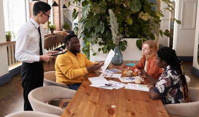 pessoas diversas conversando sobre gestão de restaurante com papeis na mesa - Assaí Atacadista