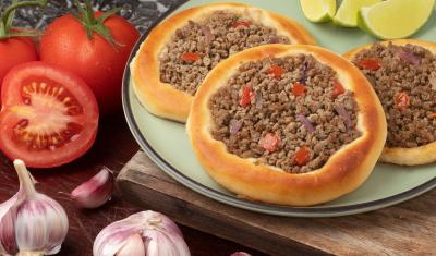 prato com esfirra de carne caseira com tomate, cebola e alho ao redor - Assaí Atacadista - petiscos fáceis - Imagem Shutterstock