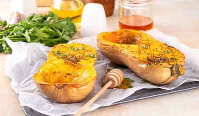 prato com uma abóbora assada cortada ao meio e ingredientes em volta - receitas veg - Assaí Atacadista