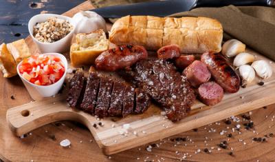 tábua com carnes assadas pão de alho e temperos diversos-churrasco de carnaval-Assaí Atacadista