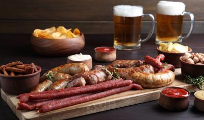tábua com carnes em uma mesa com copos de cerveja e outros petiscos em potes-churrasco perfeito-Assaí Atacadista