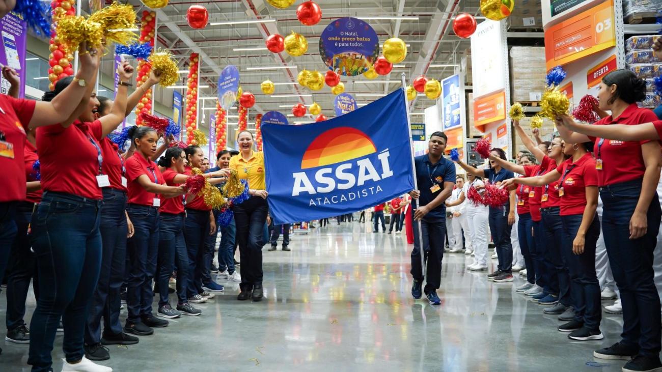 Colaboradores(as) carregam bandeira do Assaí durante cerimônia de inauguração de loja - Divulgação: Assaí