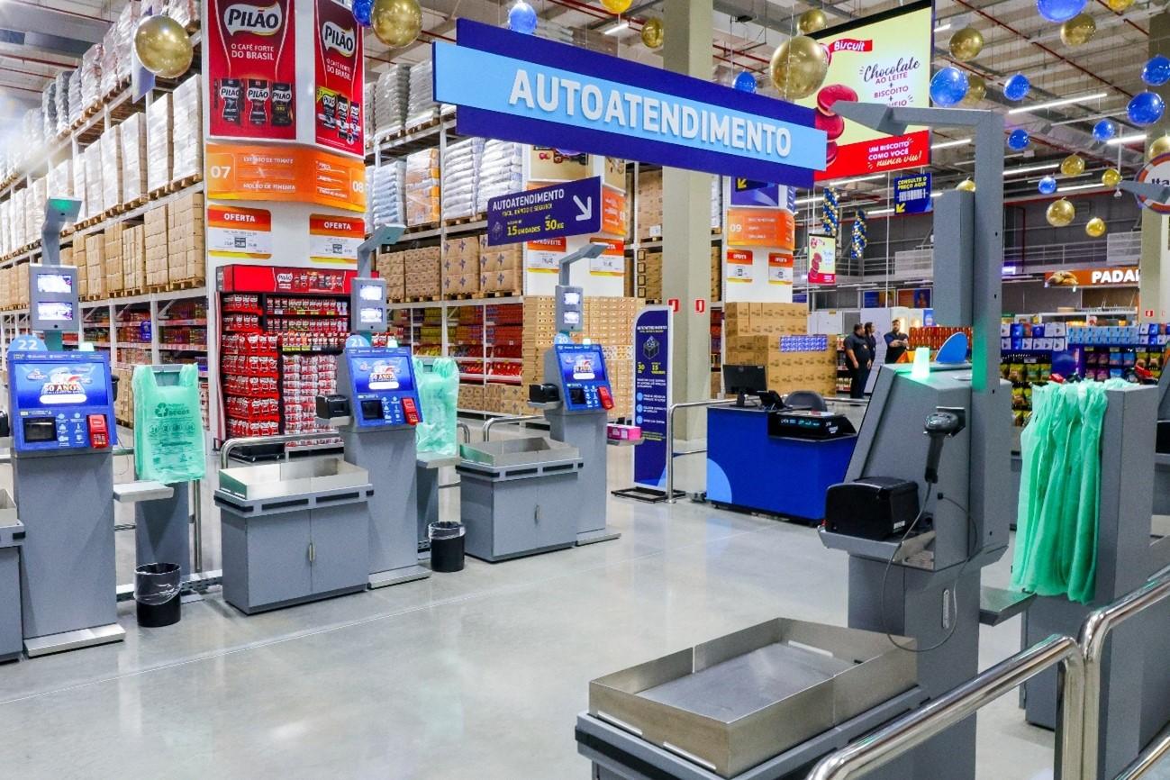 Imagem de uma seção de caixas de autoatendimento em loja do Assaí