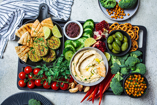 tábua de frios vegana com legumes picados e uma tigela de molho - Assaí Atacadista