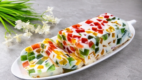travessa branca contendo gelatina branca com pedaços coloridos - receitas com frutas - Assaí Atacadista