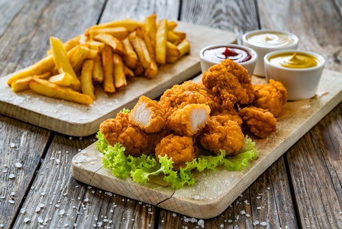 travessas brancas com batata frita e nuggets assados com pequenos ramequins de condimentos-festas com saúde-Assaí Atacadista