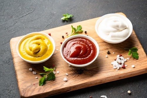 ramequins com ketchup mostarda e maionese em uma tábua-produtos Cepêra-Assaí Atacadista