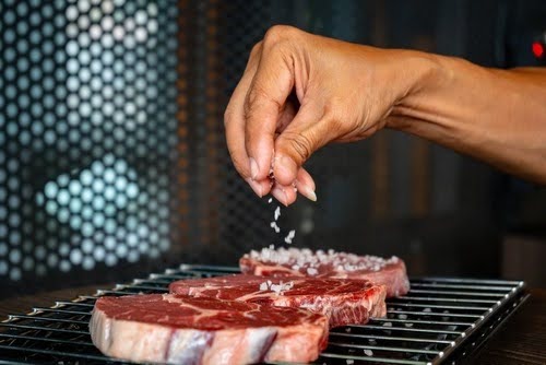 mãos usando sal de parrilla craque da brasa em uma peça de carne em uma churrasqueira-Assaí Atacadista-BR Spices