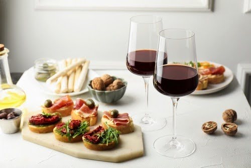 mesa com petiscos e duas taças de vinho-Vinhos Santa Carolina-Casa Flora-Assaí Atacadista