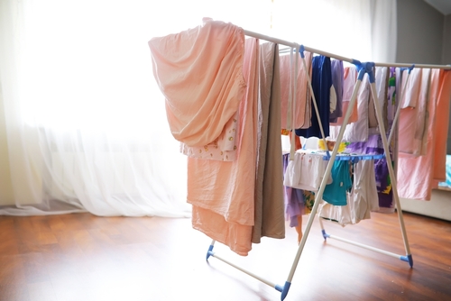 varal de chão com roupas diversas secando na sombra - Assaí Atacadista - lavar roupas de praia