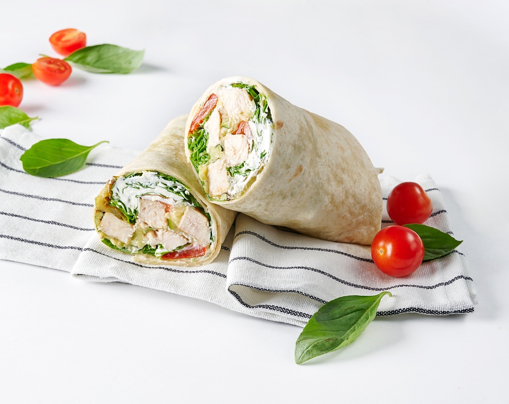 wrap de frango com alface e tomate em um fundo branco com um pano de prato - Assaí Atacadista - produtos naturais
