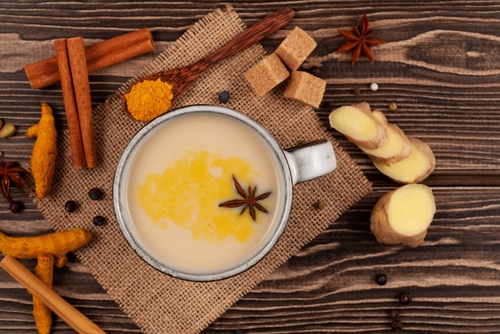 xícara com karak chai acompanhado de especiarias em um fundo de madeira - Assaí Atacadista - receitas de chás