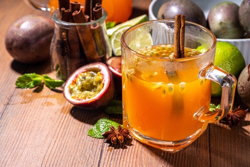 xícara transparente com chá de maracujá e um pau de canela com outros ingredientes no fundo - Assaí Atacadista - receitas de chás