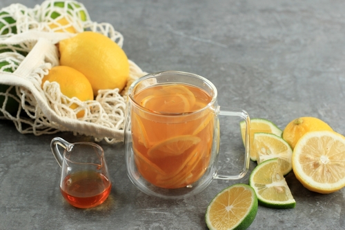 xícara transparente com Yuja chá coreano com laranjas em volta - receitas de chás - Assaí Atacadista